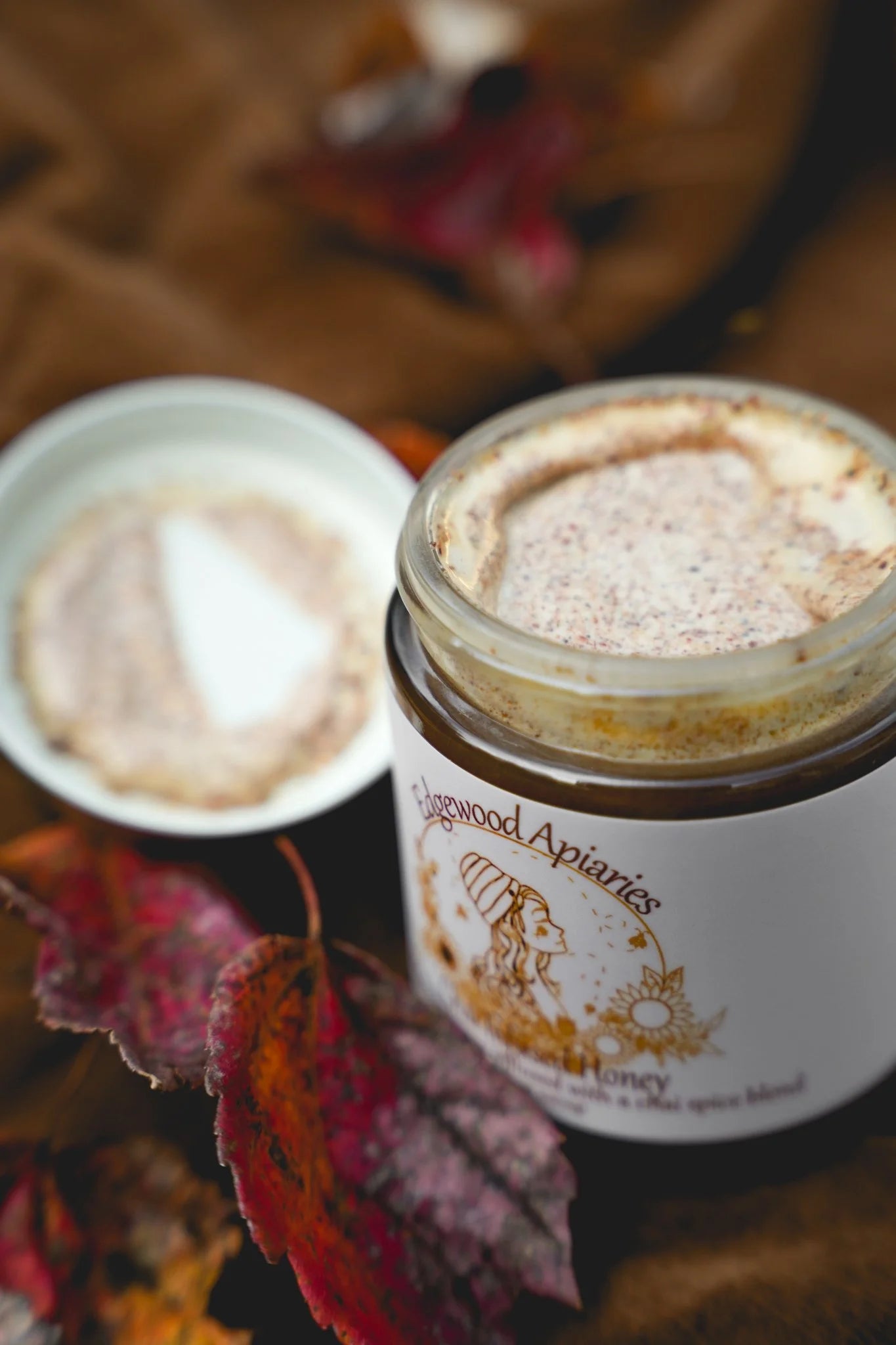 Edgewood Apiaries Chai Infused Honey on a fall background with leaves