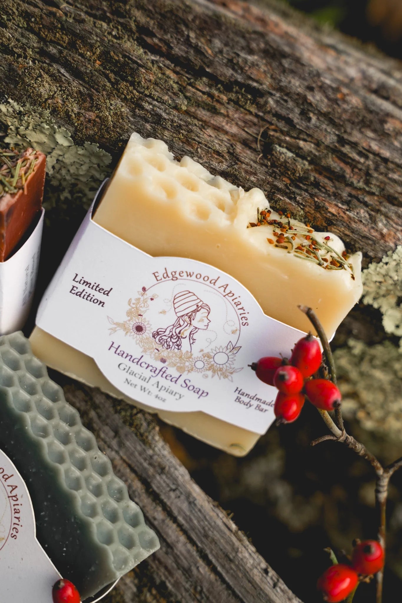 Edgewood Apiaries Glacial Apiary Handcrafted Body Soap Bar on a wooden background with festive berries