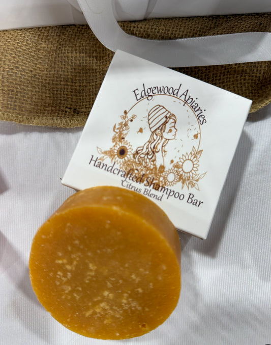 Edgewood Apiaries Handcrafted Shampoo Bar laying on product box on a linen background
