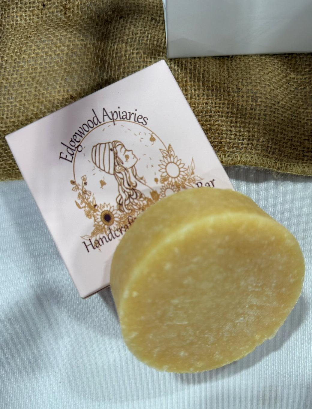 Edgewood Apiaries Handcrafted Shampoo Bar laying on product box