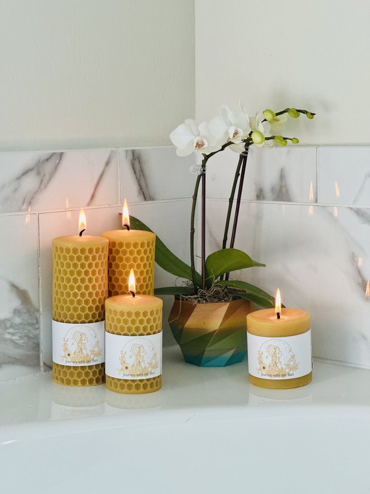 Beeswax candles with honeycomb texture, lit beside white orchid, natural home decor